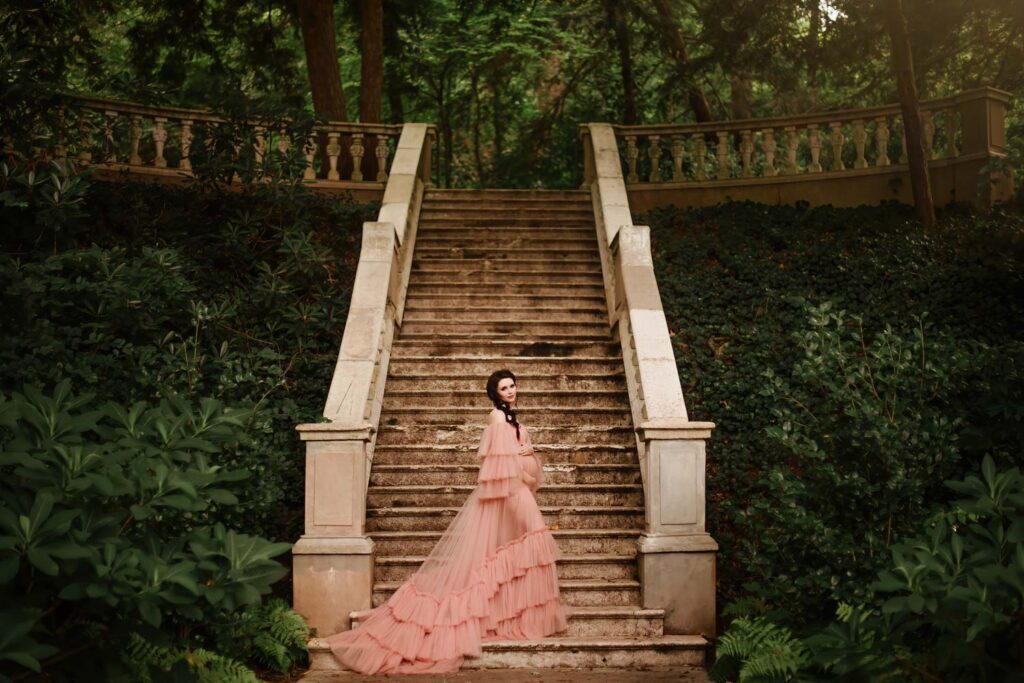 Expecting mother standing in front of the Cator Wollford Gardens grand stone staircase in Atlanta, GA