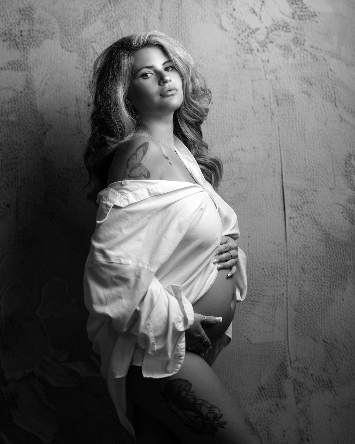 Black and white maternity portrait of pregnant woman in white open shirt photographed by sandy springs maternity photographer