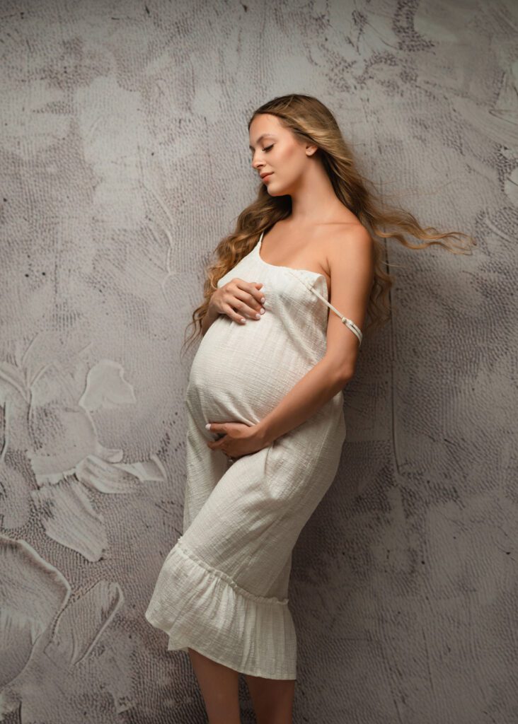 Mom-to-be in white draping cradling her belly during an Alpharetta maternity photographer session.