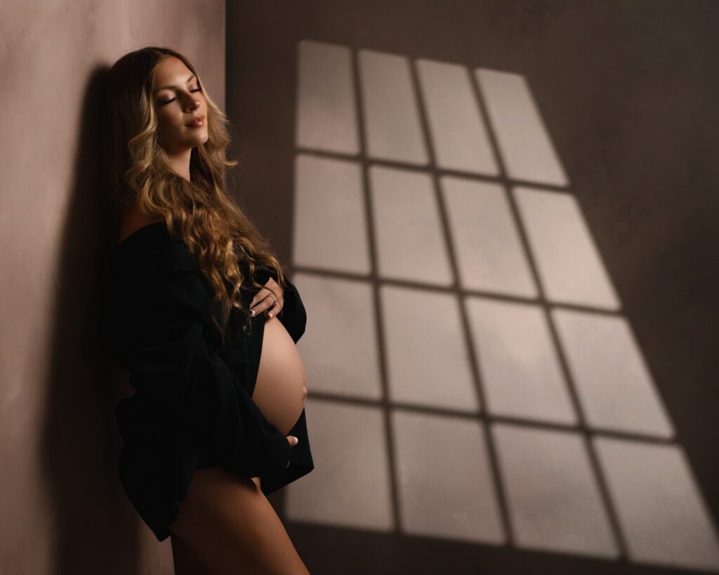 Mom-to-be in a black blazer cradling her belly during an Alpharetta maternity photography session.