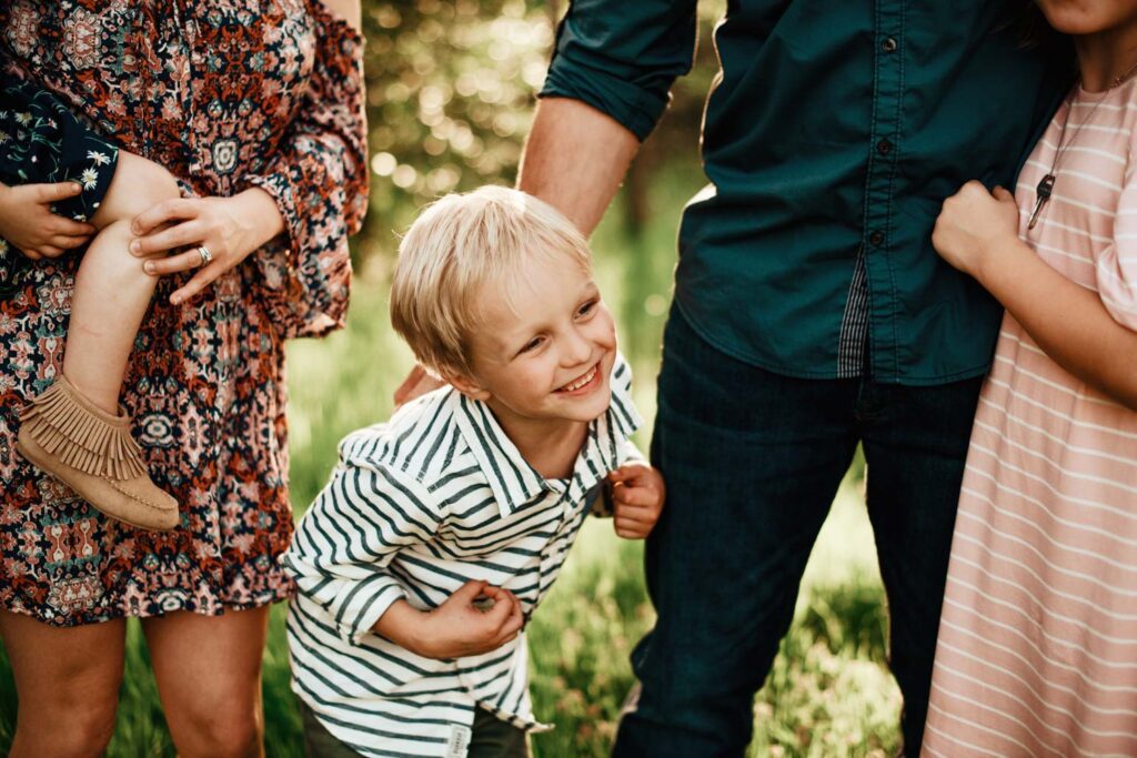 Young boy in striped shirt laughing with his family