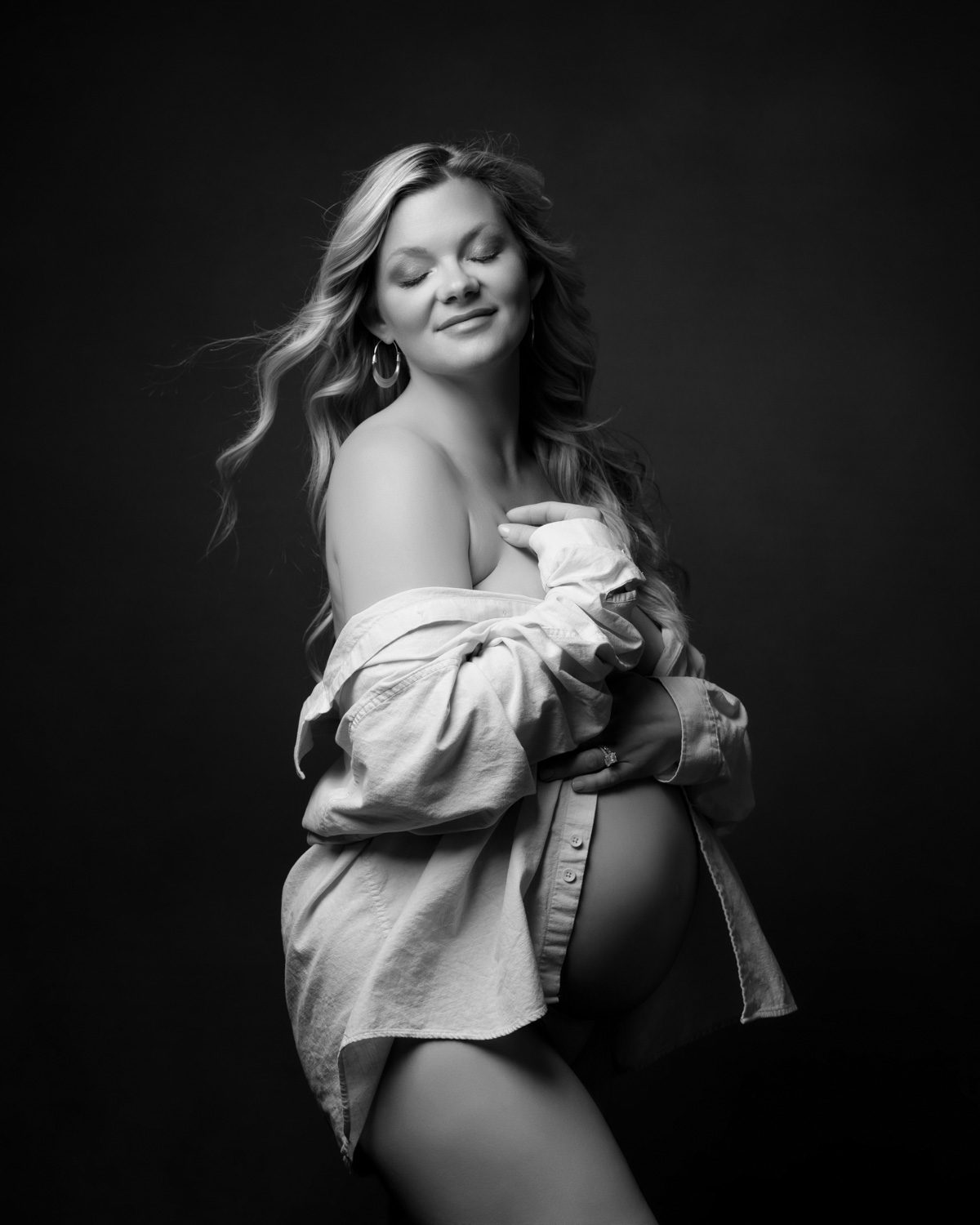 Black and white maternity portrait of an expecting mother in an open shirt photographed by a Buckhead maternity photographer.