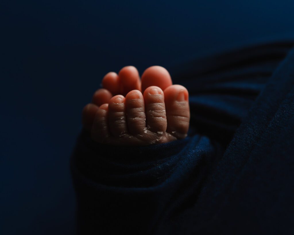 Close-up of a newborn baby girl’s tiny feet showing her toes and skin details during a Marietta newborn session.