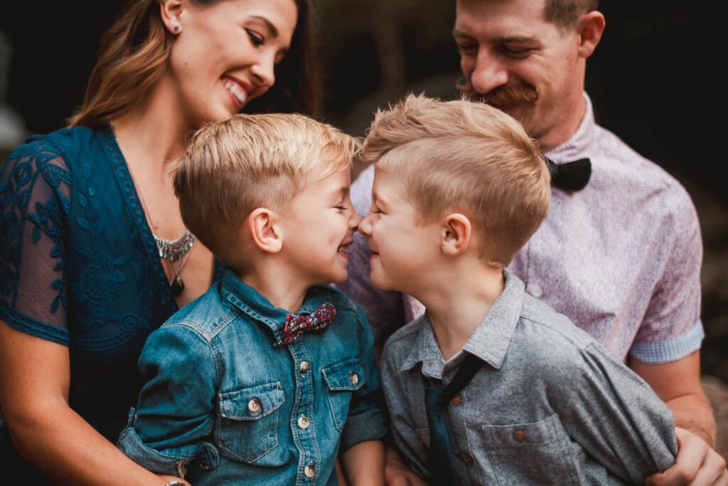 Two brothers touching noses and smiling photographed by peachtree city family photographer.
