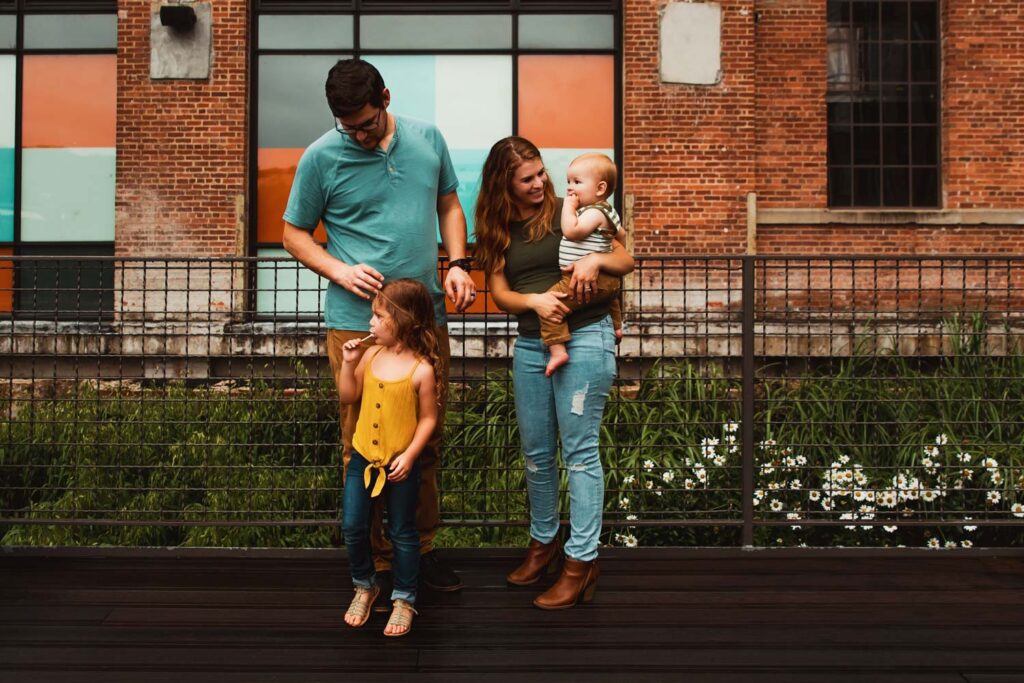 family talking on walkway with Ponce City Market colorful stained-glass-style windows in the background in Atlanta, GA.