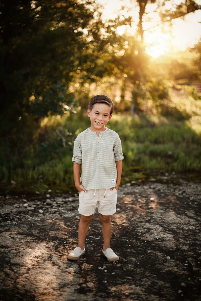 Boy standing in riverbed outdoors in soft golden light during in Stonecrest, Georgia.