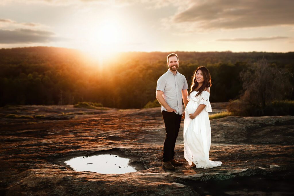 Couple posing near crater pool as the sun sets over Arabia Mountain in Stonecrest, Georgia.